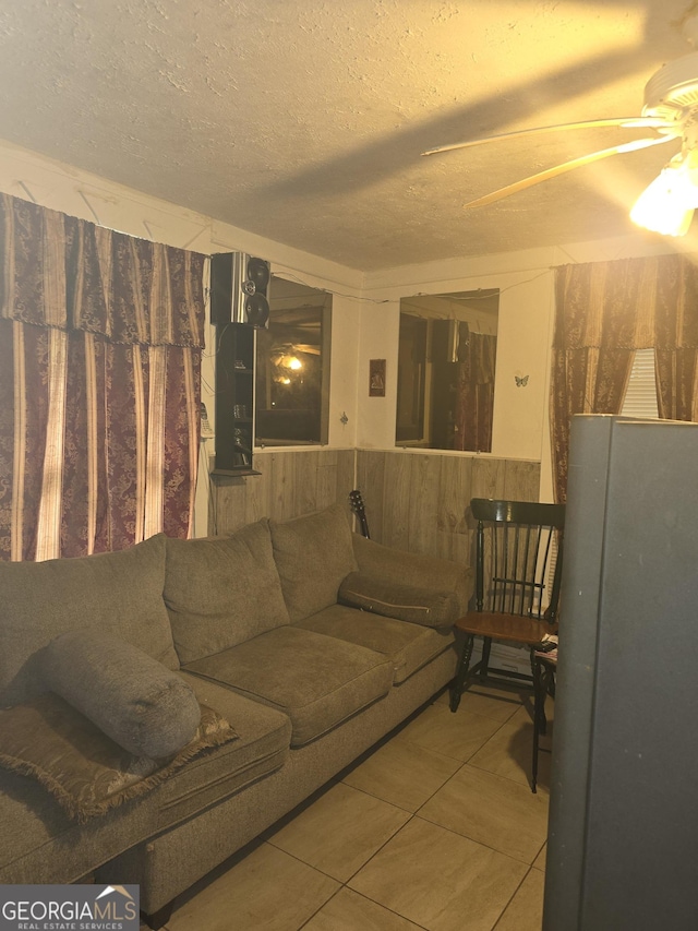 tiled living room with ceiling fan and a textured ceiling