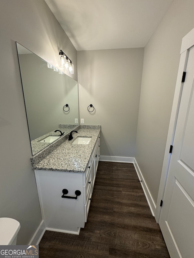 bathroom featuring vanity, hardwood / wood-style flooring, and toilet