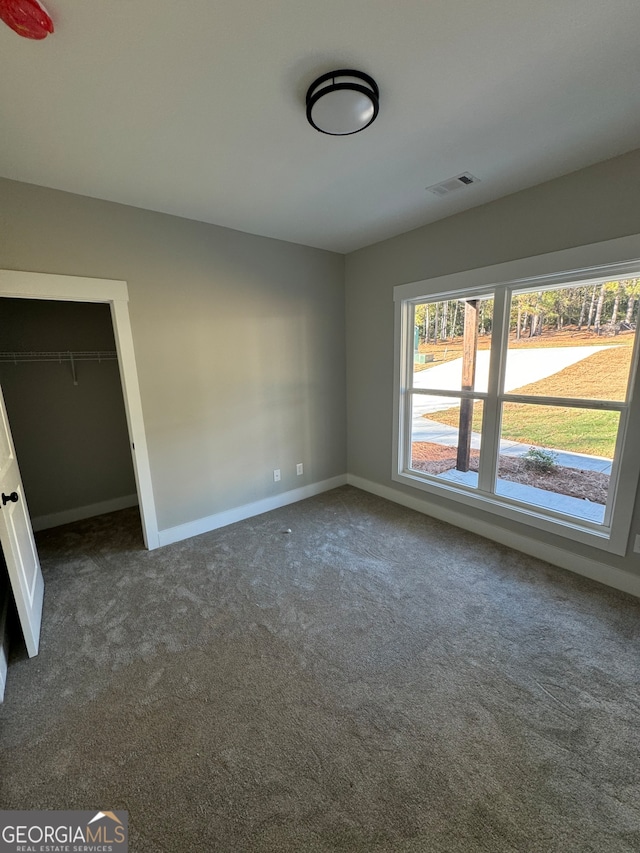 spare room with dark colored carpet