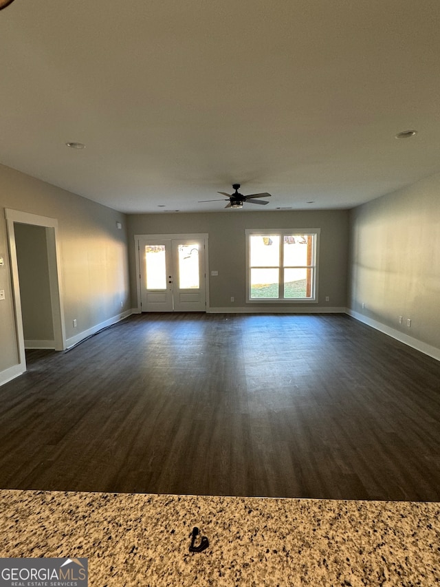 unfurnished living room featuring ceiling fan and dark hardwood / wood-style floors