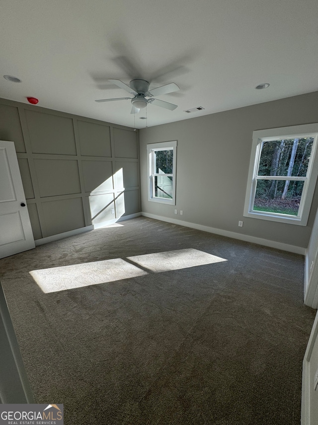 carpeted spare room with ceiling fan