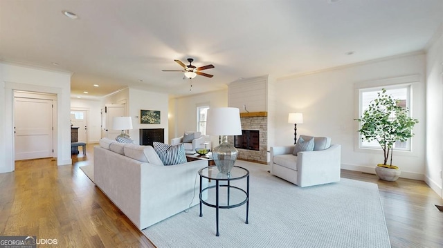 living room with a wealth of natural light, ceiling fan, and ornamental molding