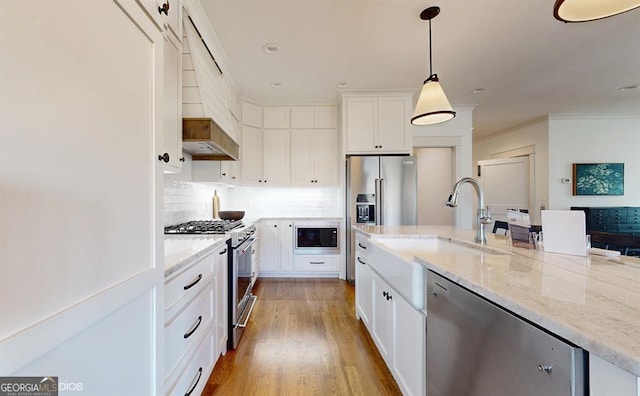 kitchen with light stone countertops, light hardwood / wood-style floors, decorative light fixtures, high quality appliances, and white cabinets