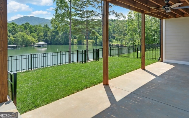 view of yard with a water view, ceiling fan, and a patio area