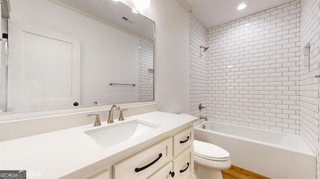 full bathroom with vanity, toilet, and tiled shower / bath combo