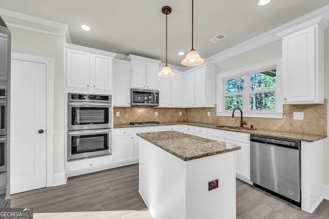1216 Trophy Club Ave, Dacula, GA 30019 - kitchen with stainless steel appliances, a kitchen island, hanging light fixtures, sink, and white cabinetry