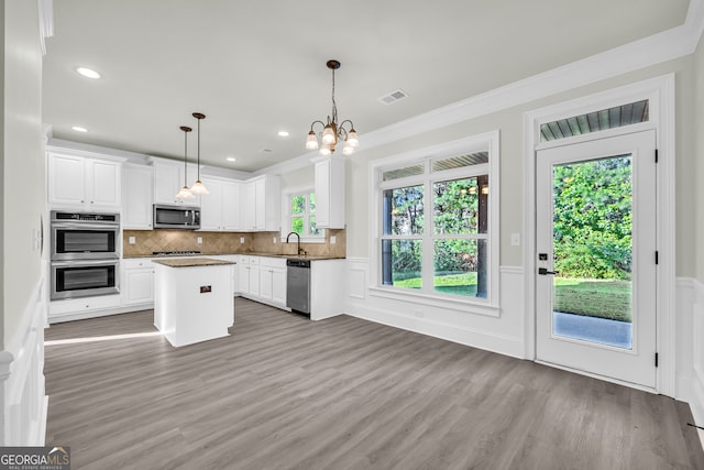1216 Trophy Club Ave, Dacula, GA 30019 - kitchen featuring hanging light fixtures, white cabinetry, wood-type flooring, appliances with stainless steel finishes, and sink