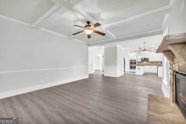 1216 Trophy Club Ave, Dacula, GA 30019 - unfurnished living room featuring beamed ceiling, ceiling fan with notable chandelier, a fireplace, and hardwood / wood-style flooring