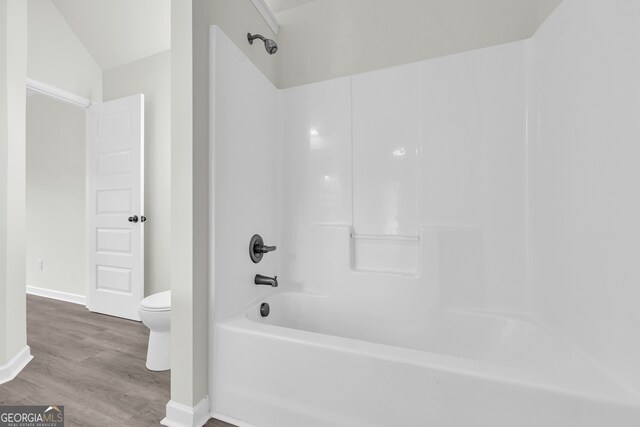 1216 Trophy Club Ave, Dacula, GA 30019 - bathroom with shower / tub combination, vaulted ceiling, toilet, and hardwood / wood-style floors