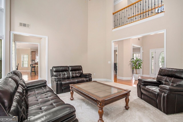 carpeted living room featuring a high ceiling