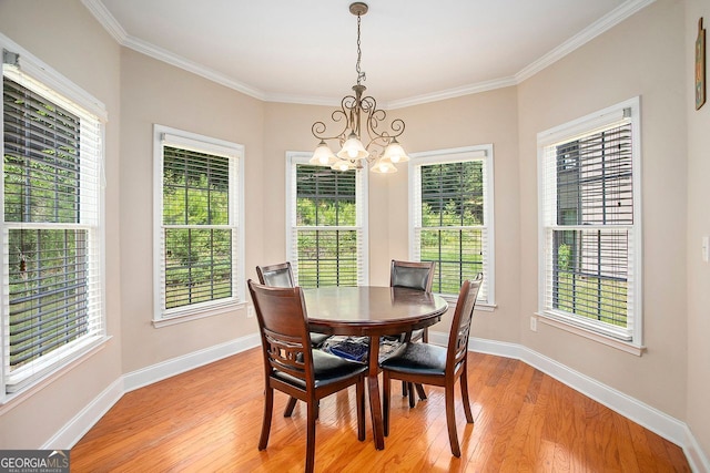 dining space with crown molding, light wood-type flooring, and a notable chandelier