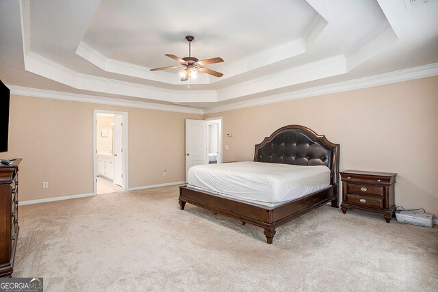 carpeted bedroom featuring a tray ceiling, ceiling fan, crown molding, and ensuite bathroom