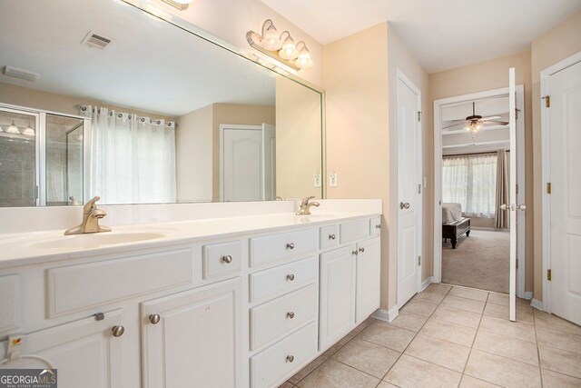 bathroom with tile patterned flooring, vanity, ceiling fan, and an enclosed shower