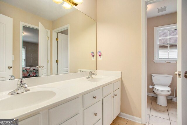 bathroom with tile patterned flooring, vanity, and toilet