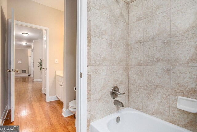 bathroom featuring vanity, wood-type flooring, and tiled shower / bath combo