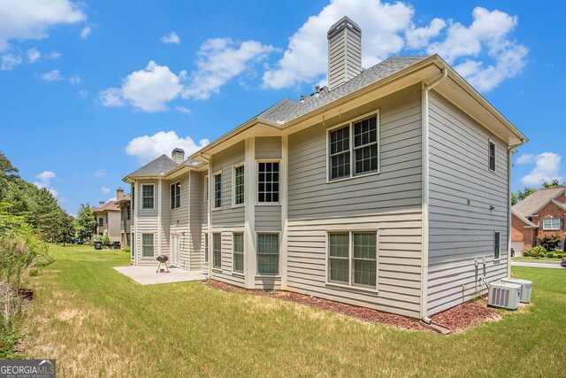 back of house featuring central AC, a yard, and a patio