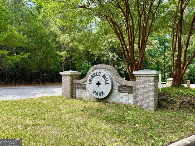 community / neighborhood sign featuring a yard