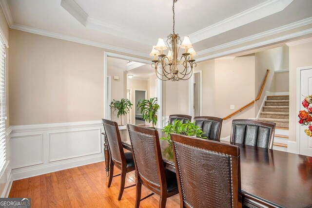 dining space with a chandelier, light hardwood / wood-style flooring, and ornamental molding