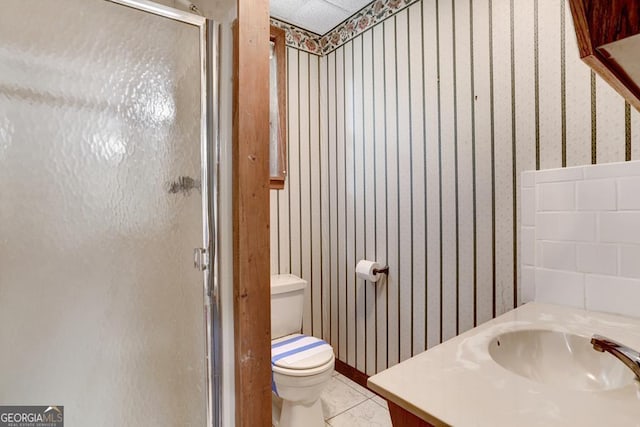 bathroom featuring toilet, vanity, tile patterned floors, and walk in shower