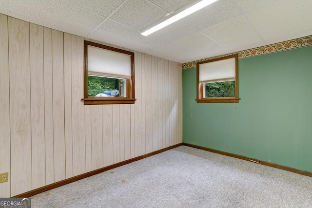 spare room with a paneled ceiling and carpet floors