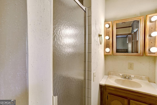 bathroom with vanity and a shower with shower door