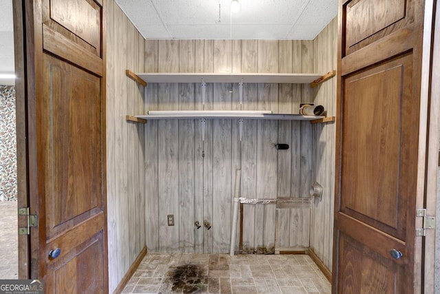 washroom featuring wood walls