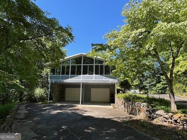 view of front of property with a garage and a sunroom