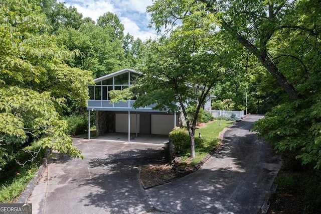 view of front of home featuring a garage and a sunroom