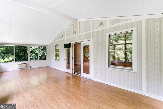 unfurnished sunroom with an AC wall unit and vaulted ceiling with beams