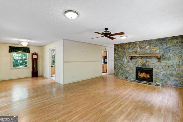 unfurnished living room with a fireplace, hardwood / wood-style floors, a textured ceiling, and ceiling fan