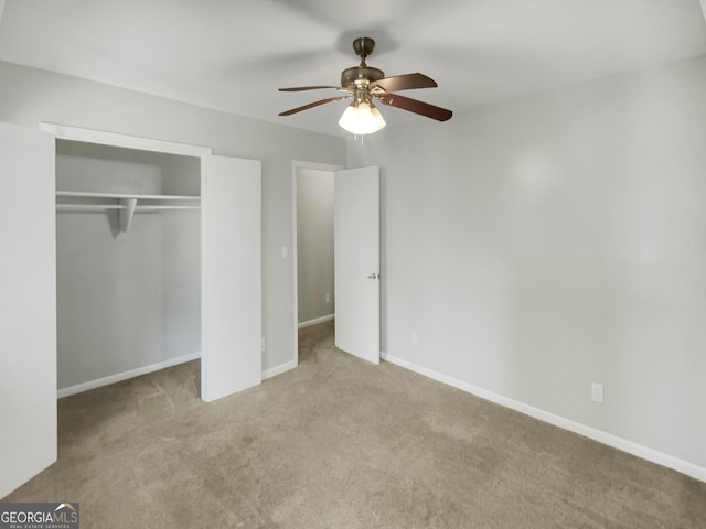 unfurnished bedroom with ceiling fan, a closet, and light carpet