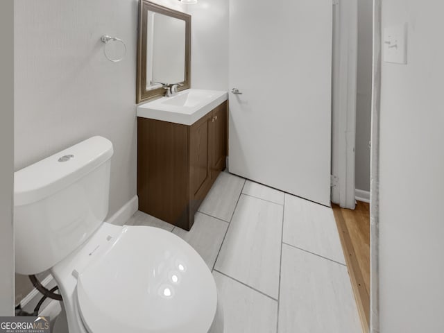 bathroom featuring hardwood / wood-style flooring, vanity, and toilet