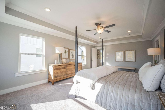 bedroom with crown molding, a tray ceiling, light colored carpet, and ceiling fan