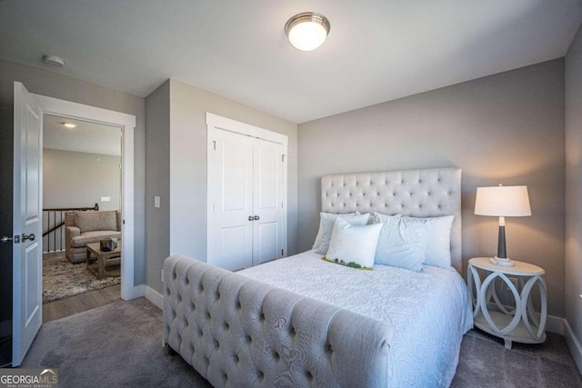 bedroom with dark colored carpet and a closet