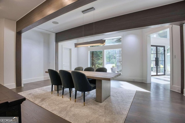 dining room featuring beamed ceiling, french doors, dark wood-type flooring, and a healthy amount of sunlight