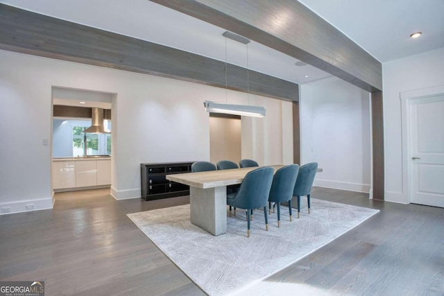 dining room with beam ceiling and dark wood-type flooring