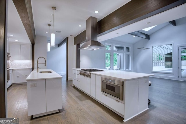 kitchen featuring a wealth of natural light, white cabinetry, a kitchen island with sink, and exhaust hood