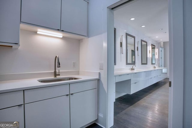 kitchen with white cabinets, sink, and dark wood-type flooring