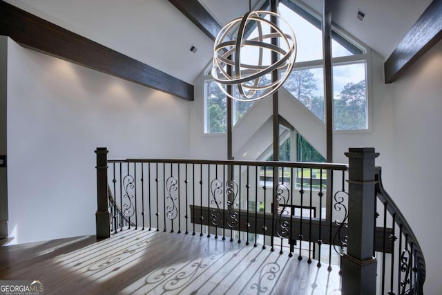 stairs featuring beam ceiling, hardwood / wood-style floors, high vaulted ceiling, and an inviting chandelier