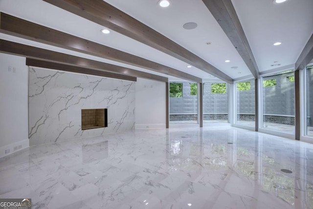 unfurnished living room with beam ceiling and a premium fireplace