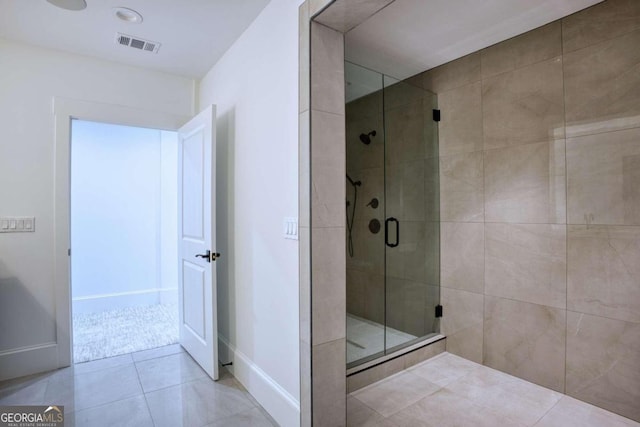 bathroom with tile patterned floors and a shower with door