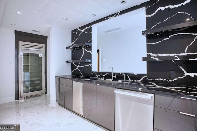 kitchen featuring sink, stainless steel appliances, and dark stone countertops