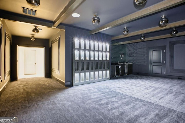 empty room featuring beam ceiling and carpet