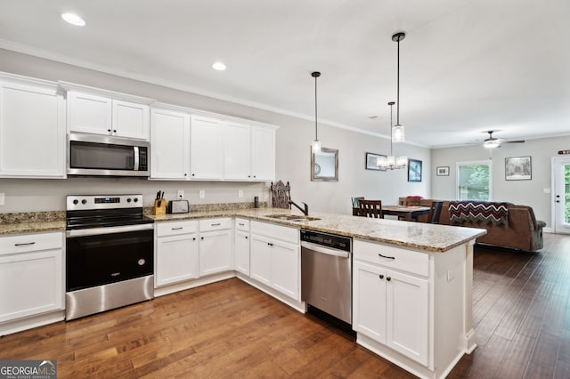 kitchen with kitchen peninsula, pendant lighting, stainless steel appliances, and white cabinets