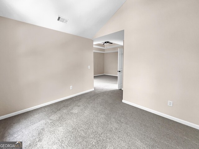 unfurnished room with vaulted ceiling, dark carpet, and ceiling fan