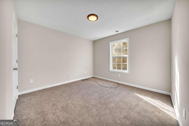 carpeted empty room with a textured ceiling