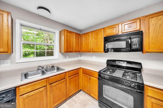 kitchen featuring a textured ceiling, sink, and black appliances