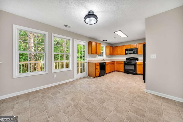 kitchen featuring a textured ceiling, sink, and black appliances