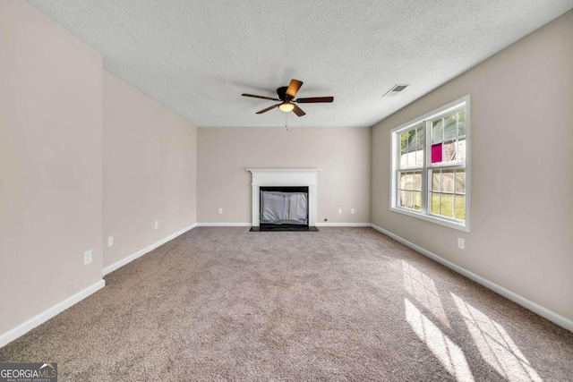 unfurnished living room featuring carpet, a textured ceiling, and ceiling fan