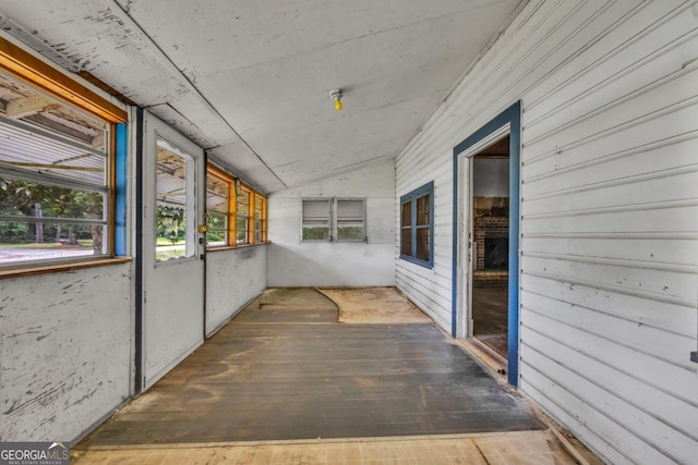 unfurnished sunroom featuring lofted ceiling